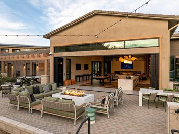 A patio with a fire pit and seating area.